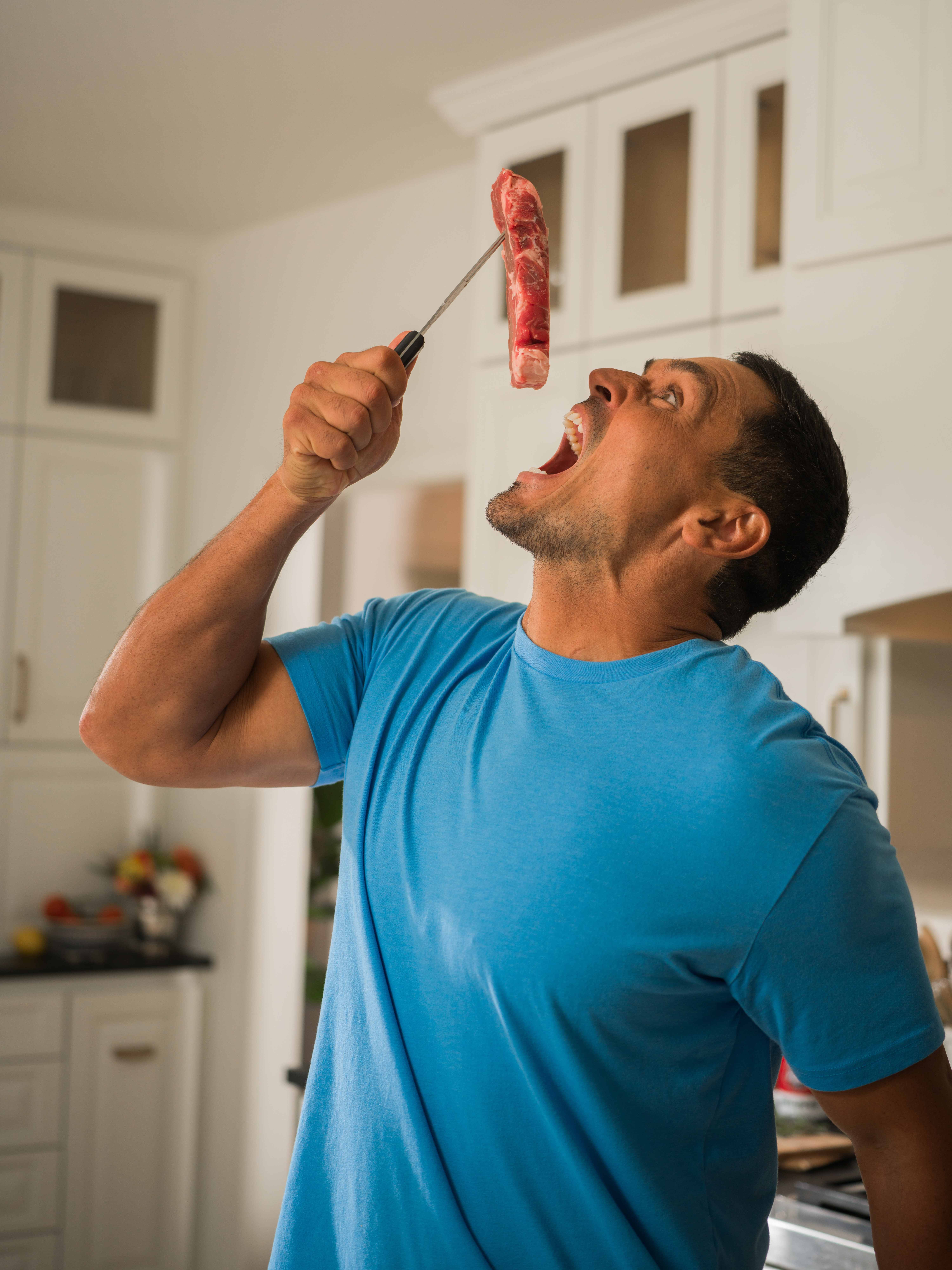 David Pollack — David in the kitchen, tossing a steak up on a fork.